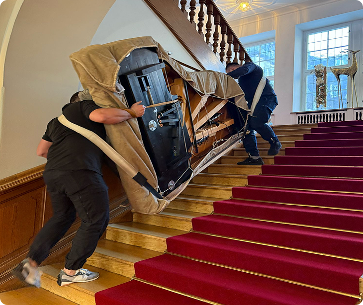 Flügeltransport Berlin – Profis tragen geschützten Flügel eine Treppe hinauf